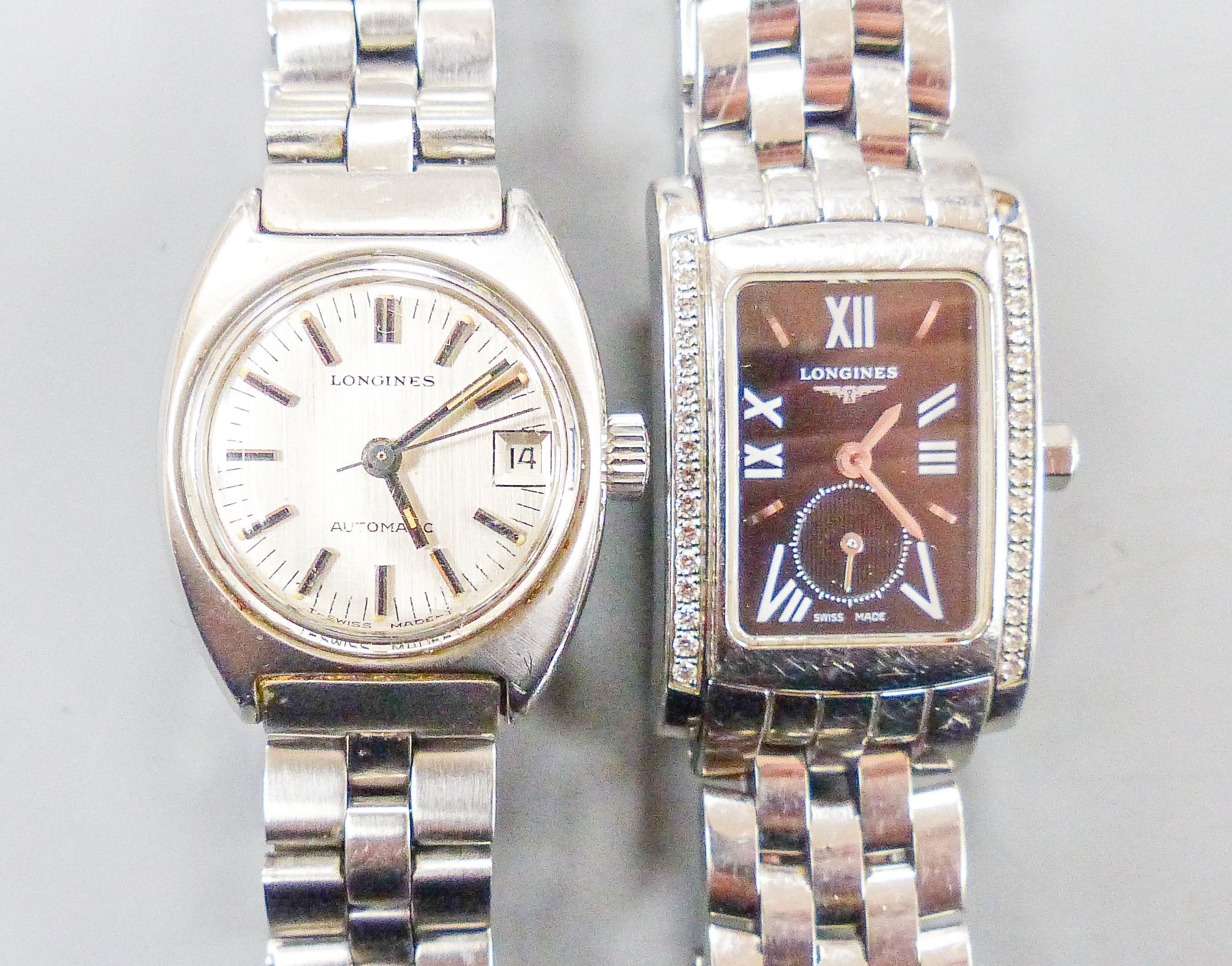 Two lady's stainless steel Longines wrist watches, one automatic and one with diamond set rectangular bezel.